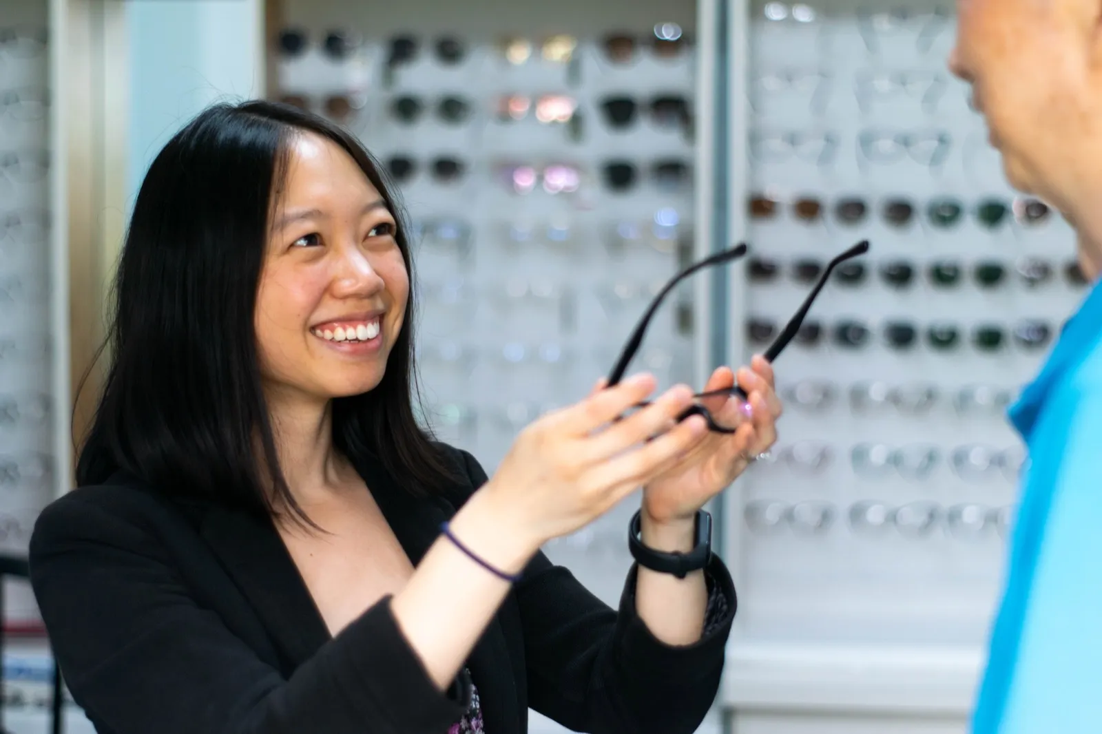 Carina helping a patient choose glasses frames