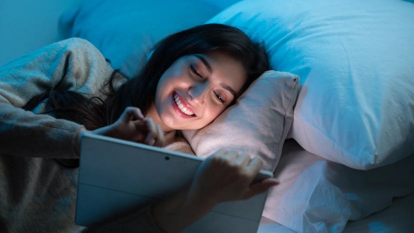 A girl watching content on tablet with low light source